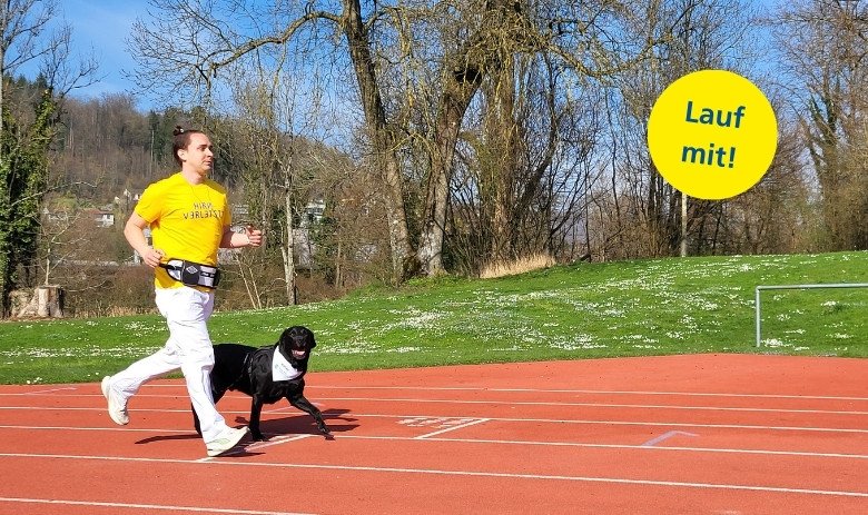 Ein junger Mann mit gelbem T-Shirt und weisser Hose läuft auf einer Laufbahn. Neben ihm läuft ein schwarzer Labrador mit. Text im Bild: Lauf mit!