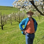 Ein Mitglied posiert vor einem blühenden Kirschbaum