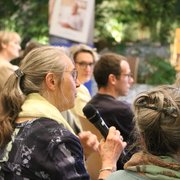 Marlène Poget, une membre du public, posant une question Une femme tient un micro et parle
