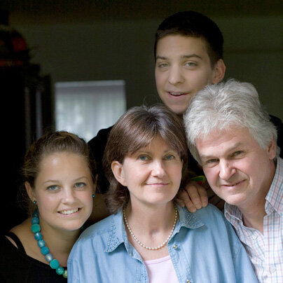 Eine vierköpfige Familie lächelt in die Kamera