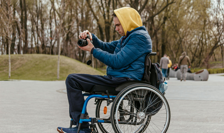 Reporters sans barrières Une personne en fauteuil roulant prend une photo avec un appareil photo