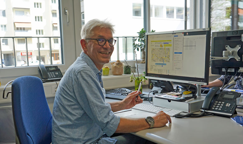 Travail Un homme riant assis face à un bureau