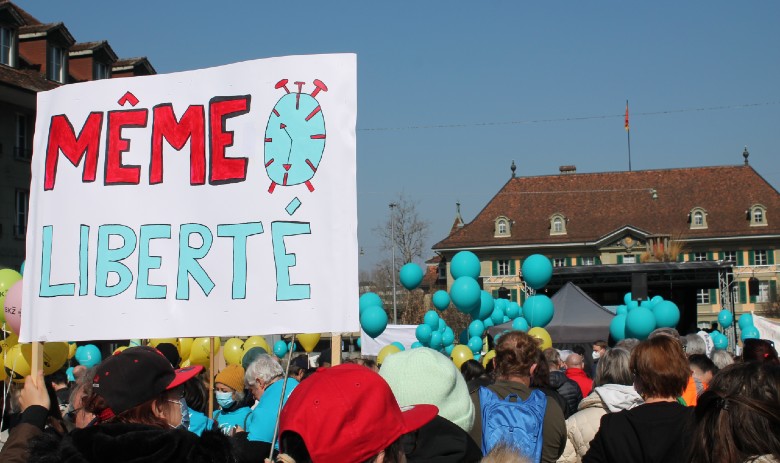 Politique Un rassemblement de personnes. Au premier plan, une pancarte "Même Liberté" est brandie.